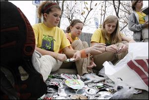 Slug:  CTY recycle16p                              Date 11/15/2009           The Blade/ Amy E. Voigt                   Location:  Toledo, Ohio  CAPTION:  Kelsey Welling, left, Haleigh Lindner, center, and Kristi Skinkiss (CQ), right, sift through cans to take the tabs off for recycling in the Toledo Zoo parking lot while they accept goods to be recycled in honor of  America Recycles Day on November 15, 2009.