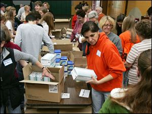 CTY kits23p  11/22/2009    Blade Photo/Lori King  Emmy Bates, left, and Lisa Seibert help fill 200 volunteer caregiver kits at St. Joseph Catholic Parish Community Center Gymnasium in Maumee, OH.