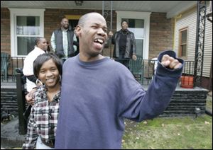 WIllie Knighten Jr., with his daughter Whitney Knighten, 17, waves to a well wisher from his Toledo home.
