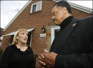 Toledoan Kimberly Bowers talks to the Rev. Jesse Jackson outside her home, which she could lose to foreclosure. A spokesman for her lender said the process has been placed on hold.