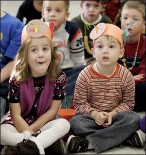 CTY feathers24p 11/20/09 The Blade/Dave Zapotosky Caption:  Mallory Barney left, and Alex Cashen, kindergarten students at Starr Elementary School in Oregon, Ohio, react as Gil Kollarik shows them animal pelts Monday, November 23, 2009.  Mr. Kollarik is a maintenance man for the Oregon schools and a long-time certified hunter education instructor. He annually does a program on wild turkeys and other wild animals for students prior to Thanksgiving.