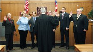 Slug: CTY oregon30p                       Date 11/29/2009           The Blade/ Amy E. Voigt                   Location: Oregon,  Ohio NOTE TO DESK: Mr. Peach was not there.  CAPTION:   Judge Jeffrey Keller of Oregon Muncipal Court, center, swears-in Oregon City Council members from left: Michael Sheehy,  Sandy Bihn, James Seaman, Dennis Walendzak, Clint Wasserman, and Terry Reeves during a ceremony on November 29, 2009.  There will be  a farewell luncheon and open house for Marge Brown, who was mayor of Oregon for eight years, at 12:30 p.m. Monday in City Council Chambers, 5330 Seaman Road.