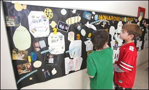 Devin Maynard, left, and Carson Webster check out the Monarchs in Space mural that Mrs. Herr's second-grade class created.