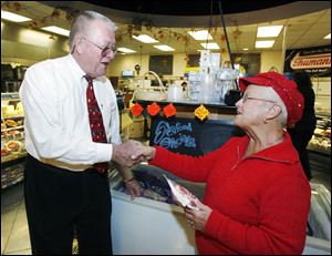 In a ritual he performs whenever he encounters a customer, Walt Churchill greets Paula Letke of Fremont, Ind. 