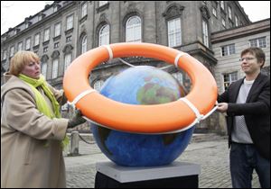 Claudia Roth, leader of Germany's Green Party, and Jakob Norhoj of the Danish Socialist People's Party place a life preserver around a globe near the parliament building in Copenhagen, the city where the climate-change summit is taking place. Representatives of 192 nations are seeking an agreement on how to address global warming.