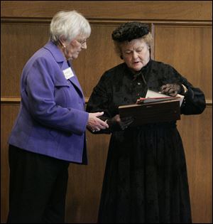 Paula Miklovic, left, discusses details of the centennial luncheon at the Toledo Club with Patsy Johnson Gaines, who attended as the personification of Susan B. Anthony.