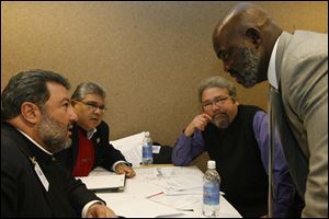 Mayor-elect Mike Bell, right, confers with his 'Efficiency and Standards' task force - the Rev. Michael Billian, left, former City Council president Louis Escobar, and Maumee Mayor Tim Wagener.