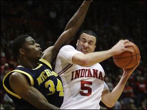 Indiana's Jeremiah Rivers is fouled by Michigan's DeShawn Sims in yesterday's game. The Wolverines fell to 6-6.