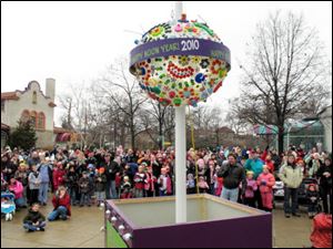 A crowd watches as the ball drops during the ‘Happy Noon Year' celebration at the Toledo Zoo. Family friendly activities were featured at the event yesterday — held at noon so children could take part — and celebrants toasted the new year with apple juice.