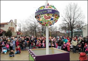 A crowd watches as the ball drops during the ‘Happy Noon Year' celebration at the Toledo Zoo. Family friendly activities were featured at the event yesterday — held at noon so children could take part — and celebrants toasted the new year with apple juice.
