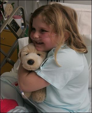 A Josh Dog brings a smile to the face of Audrey Crawford, 7, of Sylvania. Audrey was being treated for asthma.