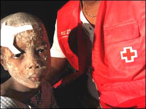 A young survivor receives aid.
Haitians piled bodies along the devastated streets of their capital Wednesday after the strongest earthquake to hit the poor Caribbean nation in more than 200 years crushed thousands of structures.