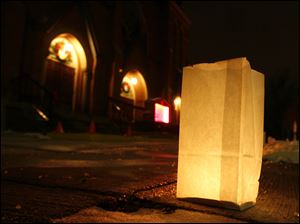 Slug: NBRN luminaria13p Date:  01062010     Andy Morrison       Location: Monroe  Caption: A luminary is lit in front of Trinity Lutheran Church as residents in the historic Old Village Plat neighborhood light luminarias along the sidewalks to recognize the 12th night or the feast of the Epiphany, Wednesday, 01062009. Summary.
