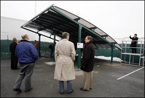 This solar roof on a carport, the first product made by ShadePlex LLC of Toledo, is shown off in a parking area next to the Maumee headquarters of the Lathrop Co. A fabric used with the panels is to improve its electricity generation. ShadePlex hopes to sell the product, which it displayed Friday, to dome and tent makers.