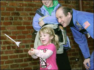 CTY frozen17p    01/16/2010       The Blade/Lori King  Grace Pizza, 4, fires off a rocket with the assistance of Reed Steele, the director of the Challenge Learning Center, during Frozentoesen activities at the Toledo Zoo.  Watching is her mom, Tracy Pizza.