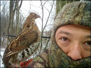 Pesky ruffed grouse sits on shoulder of Toledo hunter Eric Thompson while hunter and his son, Bradley, 13, waited in a treestand in southern Ohio.