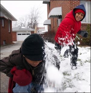 Slug: ROV snowfun            Date 1/16/2010           The Blade/ Amy E. Voigt       Location: Toledo, Ohio  CAPTION:  Christion (CQ O not a) Edwards, left, 6, gets sprayed with snow after his brother Christopher Edwards, 7, right, lobs a snowball at him on the corner of Monroe St. and Sherbrooke Rd. on January 16, 2010.