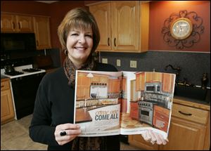 Michele Rose shows the pages of Better Homes & Gardens' Kitchen and Bath Makeovers that feature her renovation of the Westricks' kitchen.