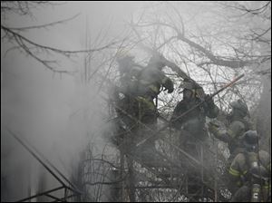 Toledo firefighters battle a blaze at 573 Segur Ave. in South Toledo. It took crews two hours yesterday to extinguish the fire, which is suspected to be arson. Toledo fire Battalion Chief Jerry Abair said the rear door of the vacant two-story building was open and someone had ignited a pile of trash inside.