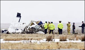 Emergency crews inspect the remains of a plane that crashed killing at least three people in a field near the Lorain County Regional Airport in Elyria, Ohio on Monday.