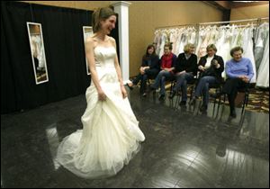 From left, Katie Lyons, Lisa Ritchie, Judy Lyons, Susan Skursha, and Lilian Homa, all family members, admire the bridal gown Jennifer Ritchie of Cleveland is modeling for her July nuptials. Ms. Ritchie shopped at the Brides against Breast Cancer Gown sale at The Pinnacle last weekend and said that although she spent more than she planned, it was worth it for the cause, not to mention the dress. All gowns were from top manufacturers and designers.
<br>
<img src=http://www.toledoblade.com/graphics/icons/photo.gif> <font color=red><b>PHOTO GALLERY</b></font>: <a href=