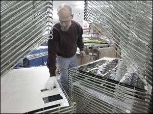 Scott Bican looks over plates to be screen printed at Glavin Industries in Solon, Ohio. An economic index is predicting growth. unemployment