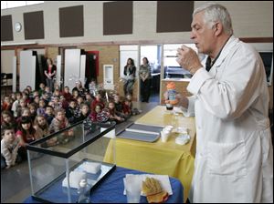 Herm Dunwald of Toledo, also known as ‘Professor Ray,' uses dry ice to make a point to the children at Wayne Trail. Mr. Dunwald is a former junior high and senior high science teacher who has been a presenter at the former COSI-Toledo. His presentation Thursday showed the youngsters how matter changes.