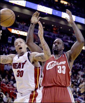 Heat forward Michael Beasley (30) fights for the ball with Cavaliers center Shaquille O'Neal. O'Neal finished with 19 points.