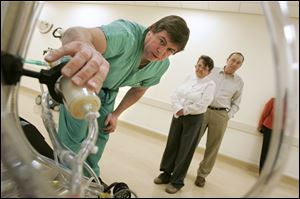 Kevin Fleming, a perfusionist responsible for the heart-lung machine during surgery, explains a modern version to Sandra Katschke and her husband, Ed.