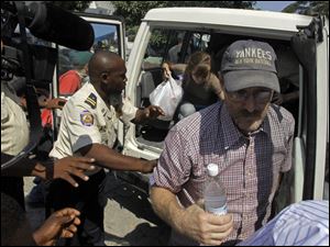 Police escort Steve McMullin and Nicole Lankford, at back, to court in Port-au-Prince for questioning about their attempt to take children from Haiti.