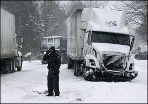 Trooper Stacey Arnold of the Ohio Highway Patrol monitors traffic after a truck accident on U.S. 24 west of Waterville.