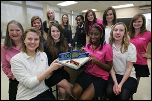 St. Ursula Academy Science Club members with their NASA's Dropping in a Microgravity Environment entry are, clockwise starting at the center front left of the board, Madeline Niehaus, 16, Abby Rieker, 17, holding the board's left corner, adviser Jackie Kane, Sydney Schwab, 16, Gretchen Savage, 16, Stephanie N. Szczesniak, 16, Nicole Ishimwe, 15, Cassie Pacer, 17, Liz Garrison, 17, Shannon Martin, 17, Danyel E. Wigmans, 14, and Nikeya Dickson, 18, holding the board's right corner.