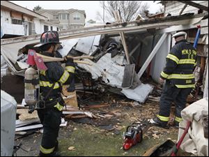Menlo Park firemen look at the scene of a small plane that crashed into a house in East Palo Alto, Calif., Wednesday.