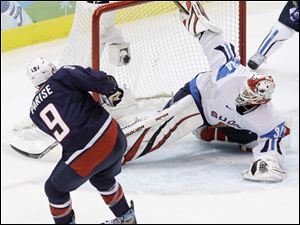 American Zach Parise scores a goal against Finland's Miikka Kiprusoff. The United States will play for the gold medal tomorrow.