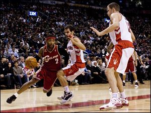 The Cavaliers' Mo Williams drives to the basket against the Raptors' Jose Calderon, center, and Rasho Nesterovic. Williams sparked the Cavaliers in overtime.
