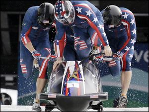 The U.S. four-man bobsled team starts down the track.