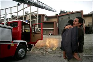 Toppled buildings form the backdrop for a man and a child in heavily damaged Concepci n.
