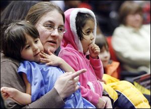 JoAnn Sanchez holds her 3-year-old twins, Joey and Jenna, as they listen to the Libbey jazz ensemble.