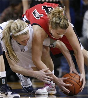 The Rockets' Lisa Johnson, left, fights for the ball with Ball State's Emily Maggert. Yesterday's division title for Toledo was the first for Johnson and two other seniors. 'It's awesome,' she said.