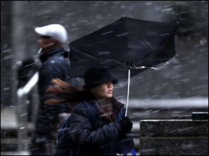 Snowstorms that shut in shoppers in February also chilled sales at women's clothing stores, compared with sales from a year earlier. Here, a pedestrian's umbrella is turned inside out by a strong gust of wind during a winter snow storm in Philadelphia.