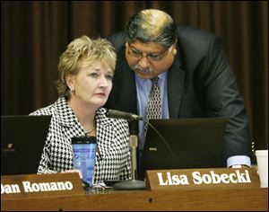 Lisa Sobecki and board President Bob Vasquez confer before the special board meeting. Mr. Vasquez said that cutting district programs to the bone affects more than just dollars and cents.