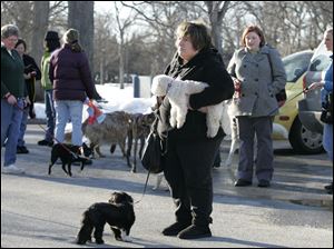 Supporters of a proposed dog park - including Tina Yoppolo, center, with Bella, on the ground, and Max, in her arms - watch as the Ottawa-Jermain advisory board holds a news conference. 