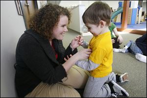 Melissa Grzybowski tickles Luke Lyons during a therapy session at Mercy Children's Hospital. 
