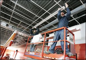BIZ build07p   3/3/2010  The Blade/Dave Zapotosky Caption: Nick Carson, left, and James Land, of Bash and Associates, Indianapolis, Ind., install a light fixture at the AutoZone store under construction in an existing building at 7229 West Central Ave. in Toledo, Ohio, March 3, 2010.
