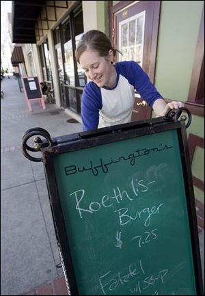 Katie Keller erases a sign promoting a 'Roethlis-Burger' lunch special at Buffington's, a bar the quarterback reportedly went to in Milledgeville, Ga.