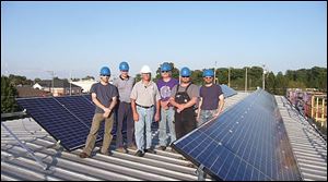 A crew with Superior Energy Solutions of Ottawa, Ohio, gathers at a solar-powered energy system installed by the company.