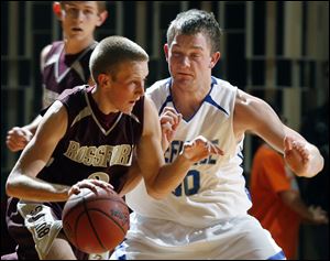 Rossford's Josh Perry tries to get past Defiance's Dace Kime in last night's Division II district semifinal.