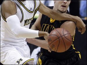 Michigan's Darius Morris, left, and Iowa's Cully Payne reach for a loose ball in the second half of an NCAA college basketball game in the opening round of the Big Ten tournament in Indianapolis, Thursday, March 11, 2010. Michigan defeated Iowa 59-52. (AP Photo/Michael Conroy) 
S6 12s6michigan 1.92
