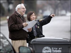 Tony Kirdahy and Lucas County Deputy Sheriff Barb Lau look over a property scheduled for sheriff's auction. 