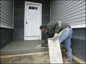 BIZ build14p  3/11/2010  The Blade/Dave Zapotosky Caption: Duane Scott of Scott's Quality Concrete, Inc., Sylvania, finishes the porch on a home under construction in the new Lakeside  subdivision off of Monclova Road near Strayer Road in Monclova Township, Thursday, March 11, 2010.  It is the only home currently under construction there.